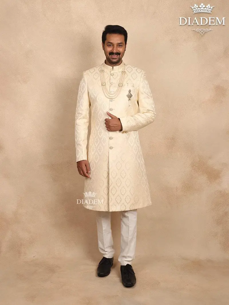 Cream Raw Silk Sherwani Suit Adorned With Floral Embroidery, Paired With Brooch And Bead Mala 1